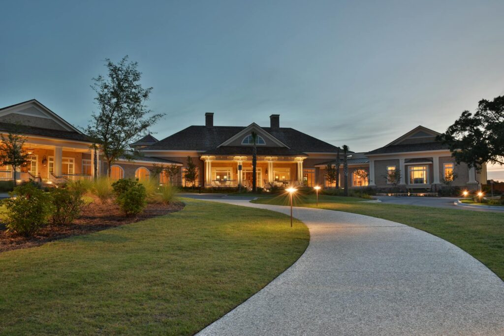 Elegant clubhouse with pathway on Hilton Head Island at twilight, capturing serene architectural beauty.